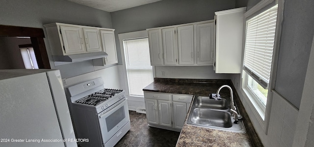 kitchen with sink, white cabinets, dark wood-type flooring, and white appliances