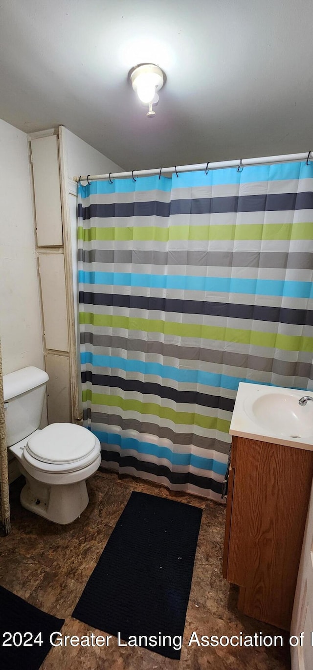 bathroom featuring vanity, toilet, and walk in shower