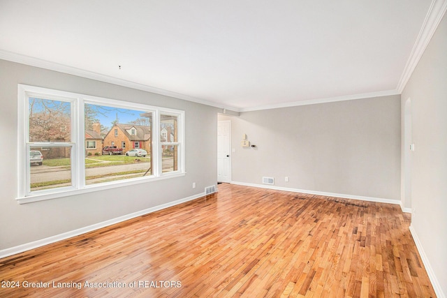 unfurnished room with light wood-type flooring and crown molding