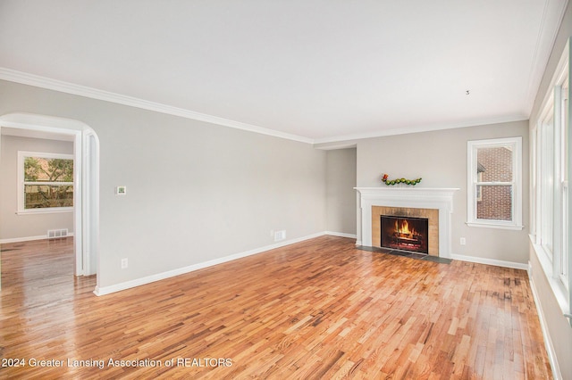 unfurnished living room featuring light hardwood / wood-style floors and crown molding