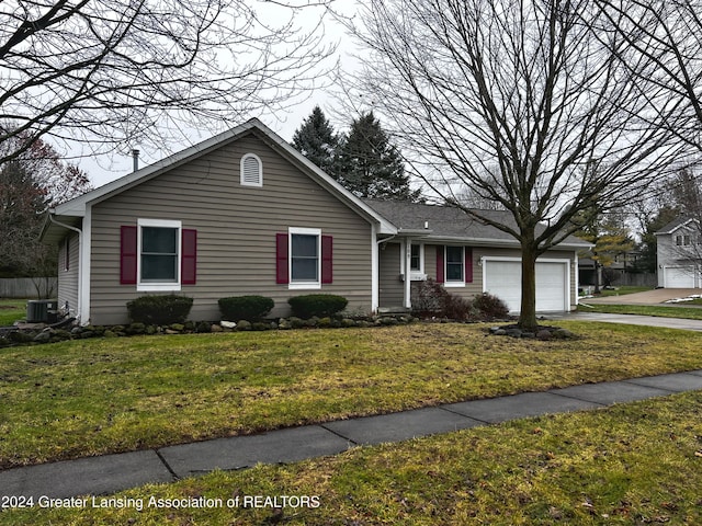 view of front of home featuring a front lawn, a garage, and cooling unit