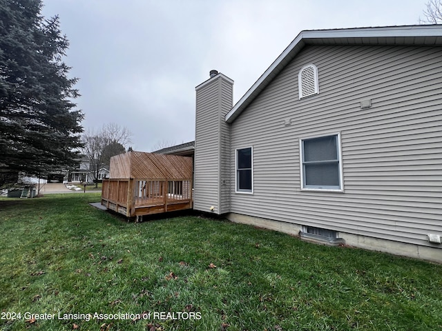 back of property with a deck and a lawn