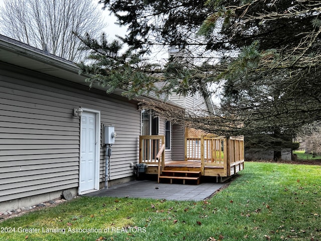 wooden terrace with a patio and a yard