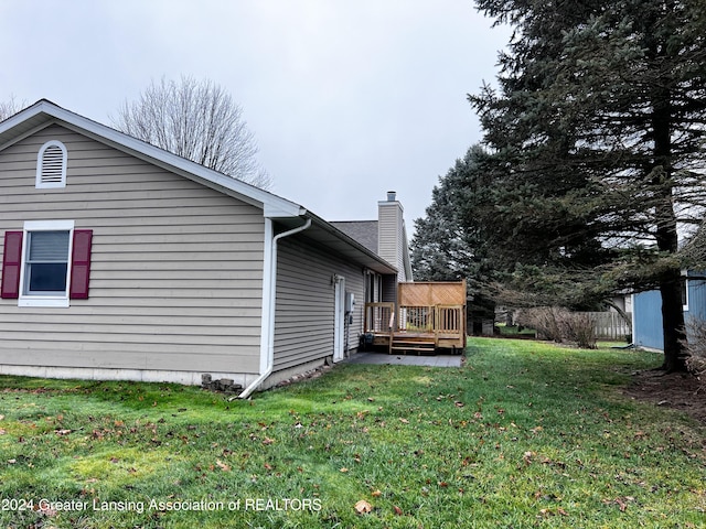 view of property exterior with a deck and a lawn