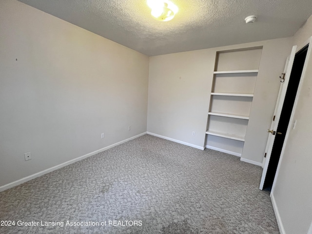 unfurnished bedroom featuring a textured ceiling and carpet flooring