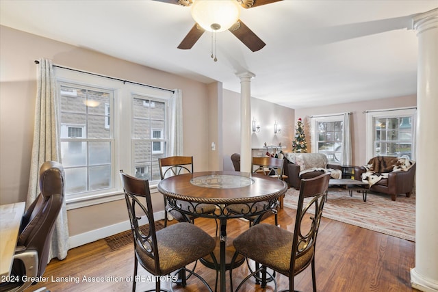 dining space with wood-type flooring, decorative columns, and ceiling fan