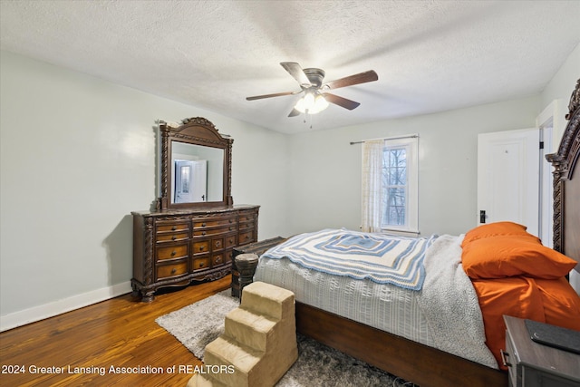 bedroom with ceiling fan, a textured ceiling, and hardwood / wood-style flooring