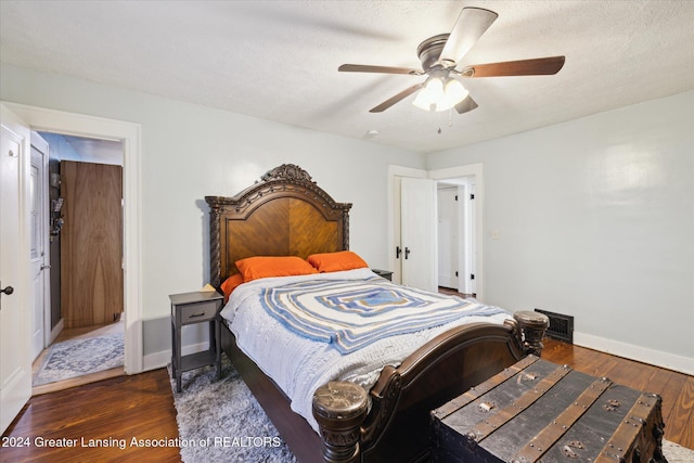 bedroom with ceiling fan, dark hardwood / wood-style flooring, and a textured ceiling