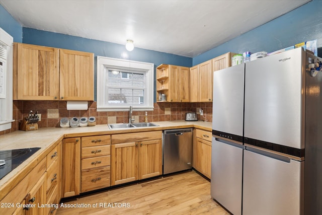 kitchen with light brown cabinets, backsplash, sink, light wood-type flooring, and appliances with stainless steel finishes