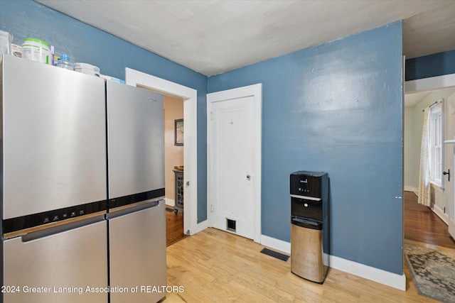 kitchen with stainless steel refrigerator and light hardwood / wood-style flooring