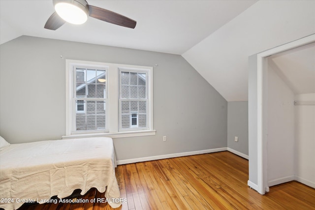 bedroom with ceiling fan, vaulted ceiling, and hardwood / wood-style flooring