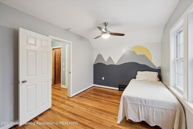 bedroom featuring multiple windows, ceiling fan, hardwood / wood-style floors, and vaulted ceiling