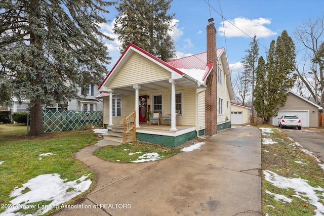 bungalow-style house with a front yard, covered porch, an outdoor structure, and a garage