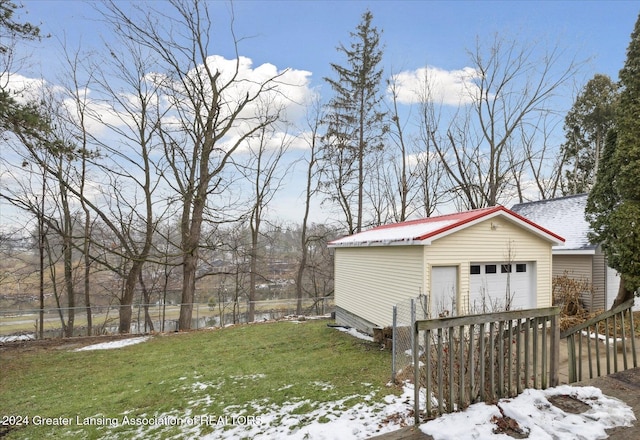 view of snow covered exterior with a yard, a garage, and an outdoor structure