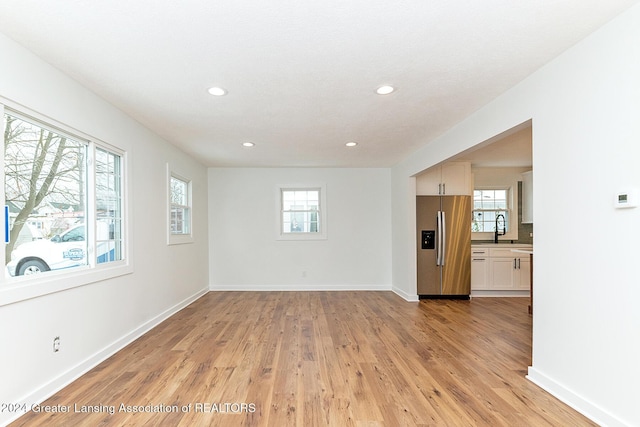 spare room with sink and light hardwood / wood-style flooring