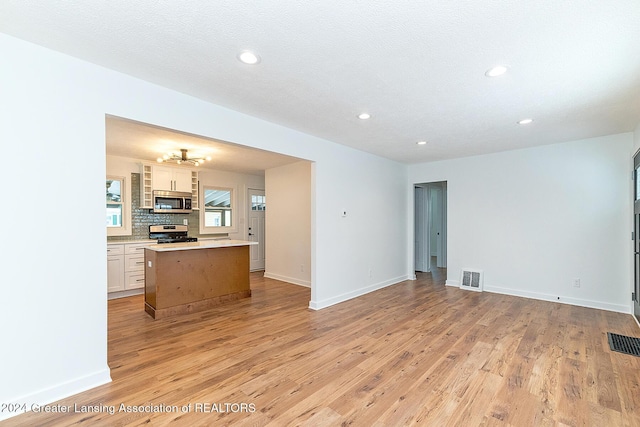 living room with light wood-type flooring and a textured ceiling