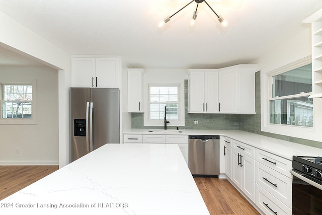 kitchen featuring decorative backsplash, light stone countertops, sink, and stainless steel appliances