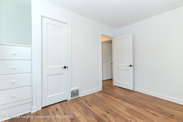 unfurnished bedroom with hardwood / wood-style floors