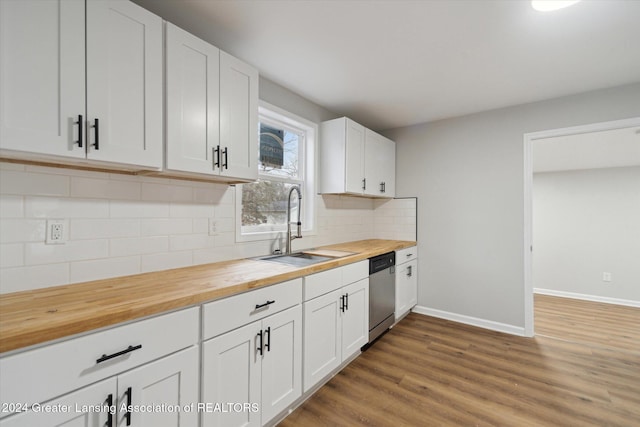 kitchen featuring stainless steel dishwasher, white cabinetry, and butcher block counters