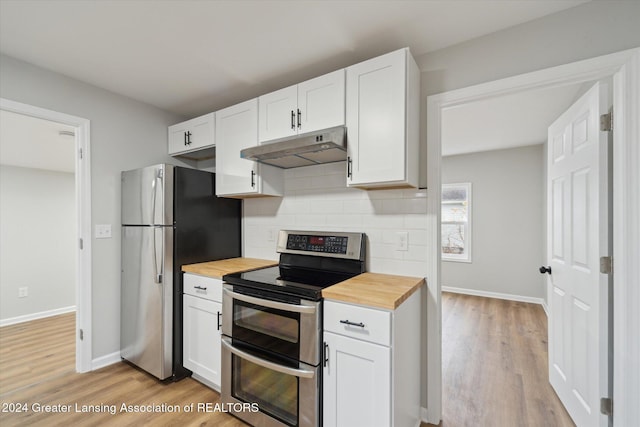 kitchen featuring appliances with stainless steel finishes, butcher block countertops, and white cabinetry