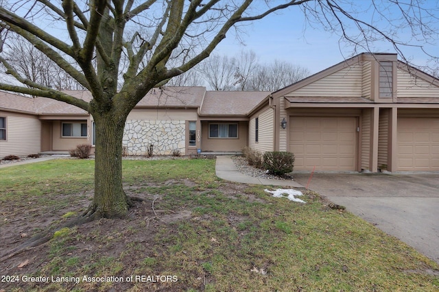 ranch-style home featuring a garage and a front lawn