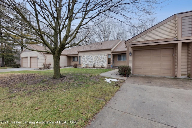 ranch-style house with a garage and a front lawn