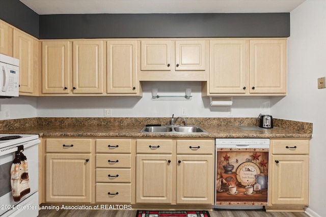 kitchen featuring light brown cabinetry, sink, and white appliances