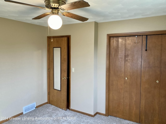 unfurnished bedroom with a closet, ceiling fan, and light colored carpet