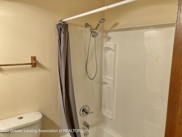 bathroom featuring toilet and shower / bath combo with shower curtain