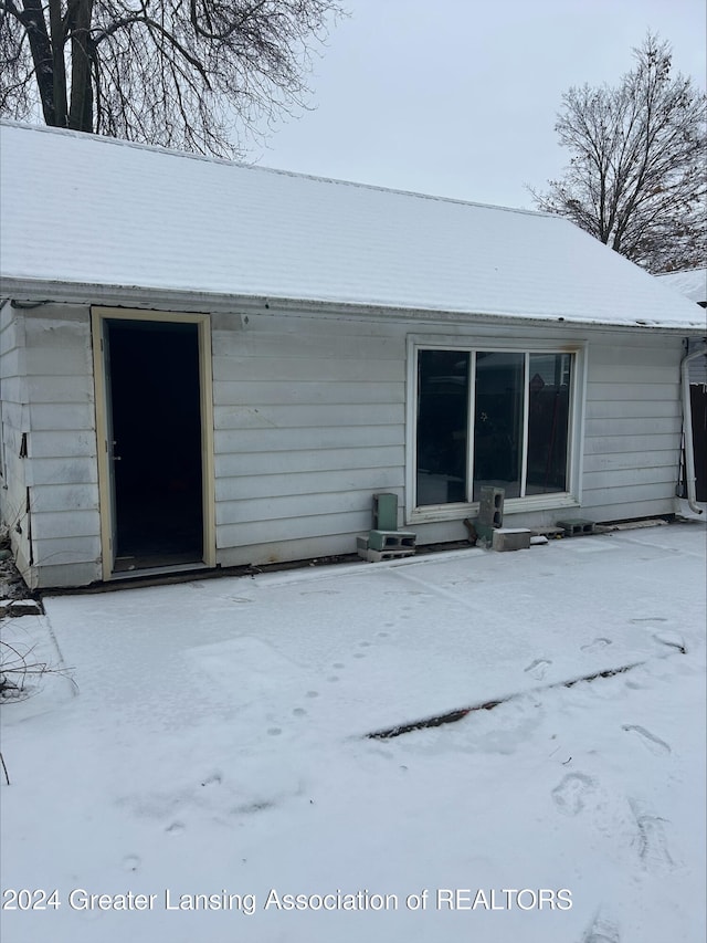 view of snow covered back of property