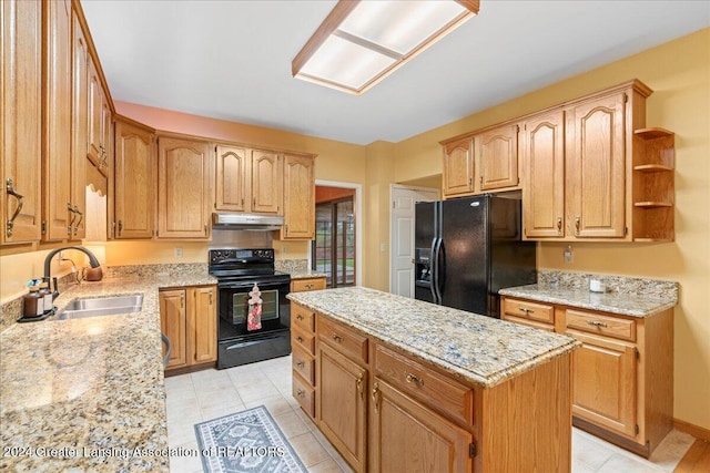 kitchen with light stone counters, sink, black appliances, light tile patterned floors, and a center island