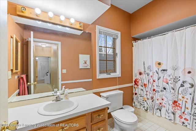 bathroom featuring tile patterned flooring, vanity, and toilet