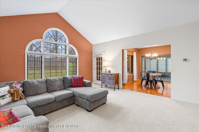 carpeted living room featuring vaulted ceiling and an inviting chandelier