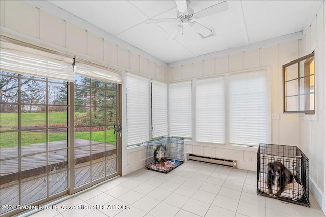 sunroom / solarium with baseboard heating and ceiling fan