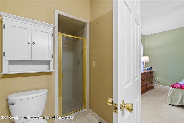 bathroom featuring toilet and a shower with shower door