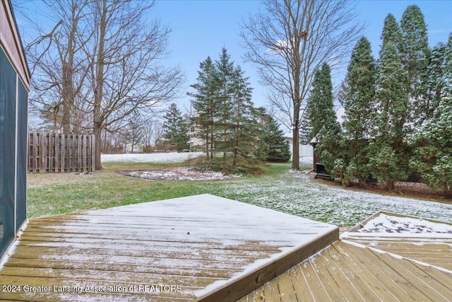 snow covered deck featuring a yard