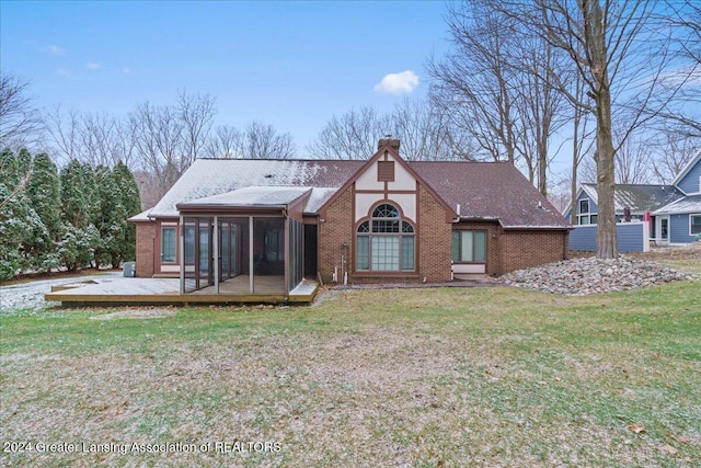 back of house with a wooden deck, a sunroom, and a yard