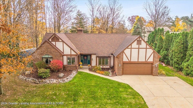 tudor house with a front yard and a garage