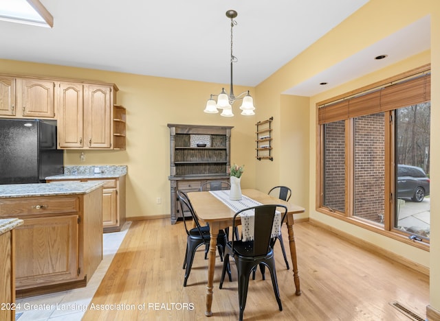 dining space featuring light hardwood / wood-style flooring and an inviting chandelier