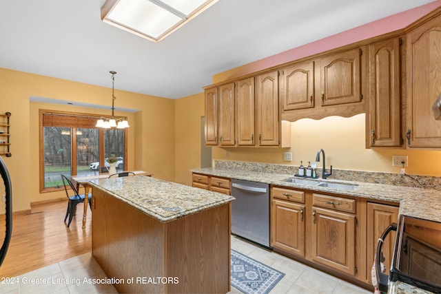 kitchen featuring stove, stainless steel dishwasher, sink, decorative light fixtures, and a kitchen island