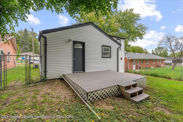 rear view of property with a yard and a wooden deck