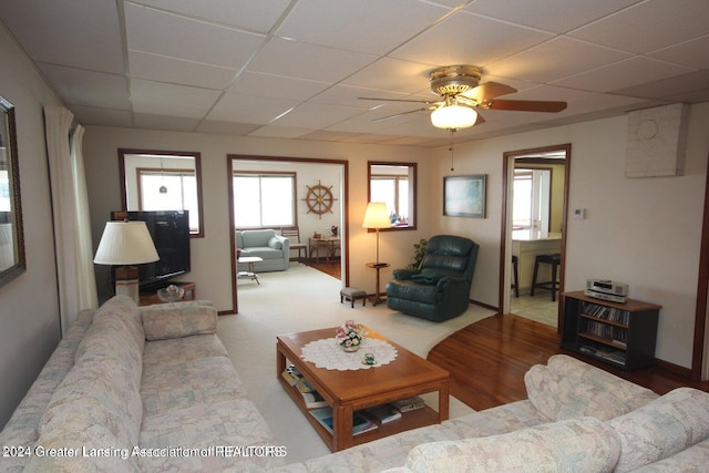 carpeted living room with a paneled ceiling and ceiling fan