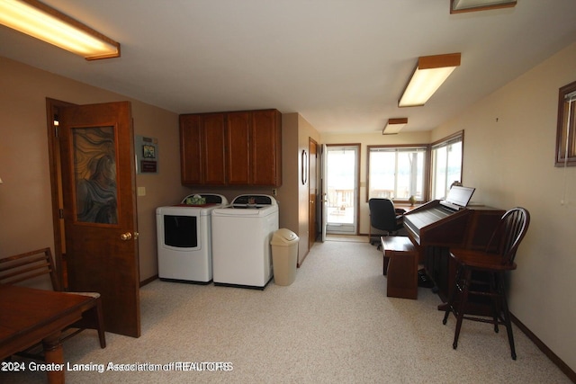 clothes washing area with cabinets and separate washer and dryer