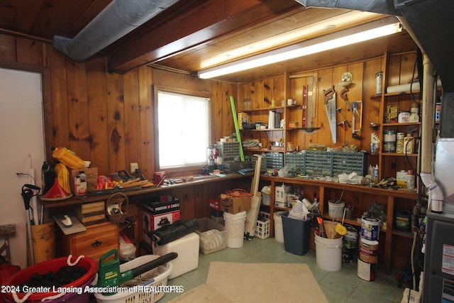 miscellaneous room with a workshop area and wood walls