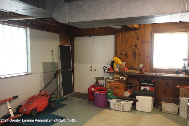 basement with a workshop area and wood walls