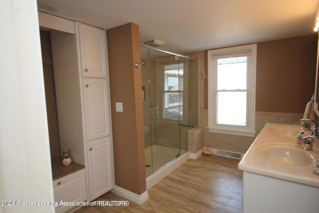 bathroom featuring hardwood / wood-style floors, vanity, and a shower with door