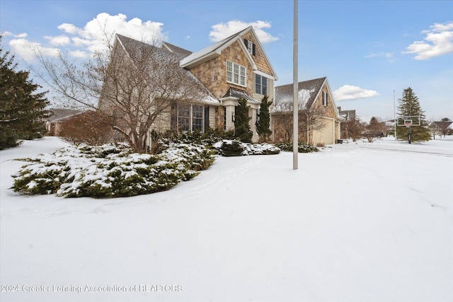 snow covered property with a garage