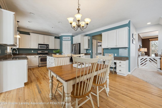 dining area featuring light hardwood / wood-style floors, an inviting chandelier, ornamental molding, and sink