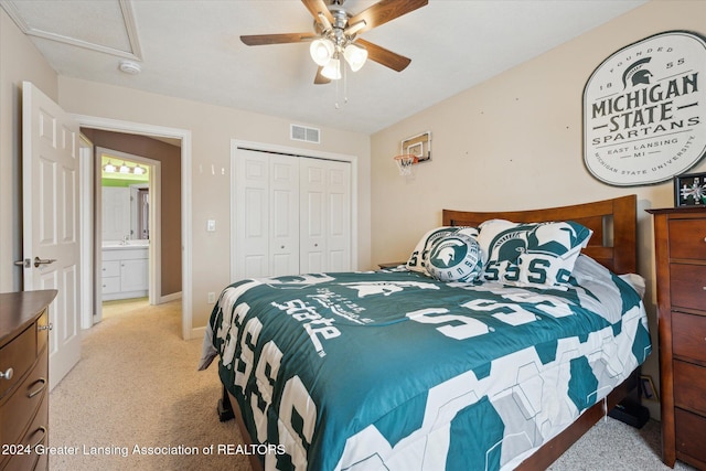 bedroom featuring ceiling fan, sink, light carpet, and a closet