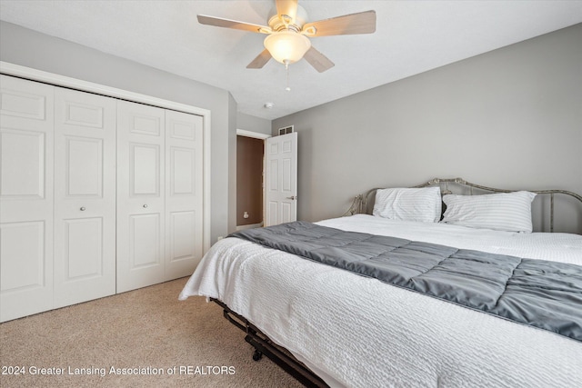 carpeted bedroom featuring ceiling fan and a closet